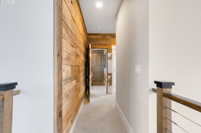 hallway with wood walls and light colored carpet