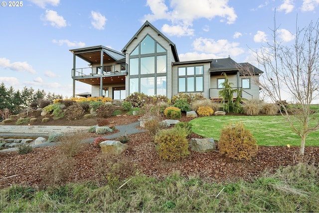 back of property featuring a lawn and a balcony