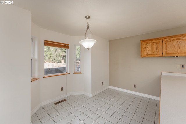 unfurnished dining area featuring light tile patterned floors