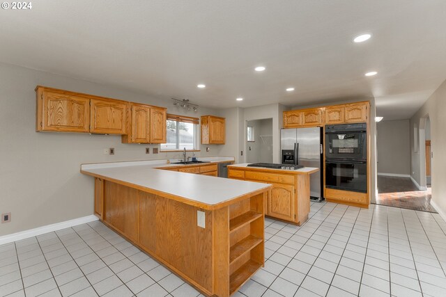 kitchen featuring stainless steel appliances, a center island, kitchen peninsula, and light tile patterned flooring