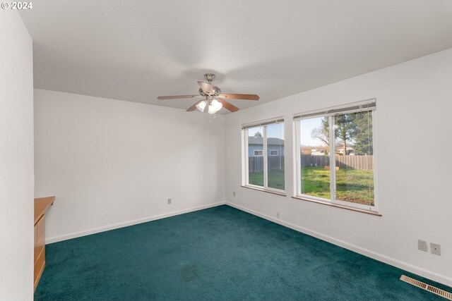 carpeted empty room featuring ceiling fan