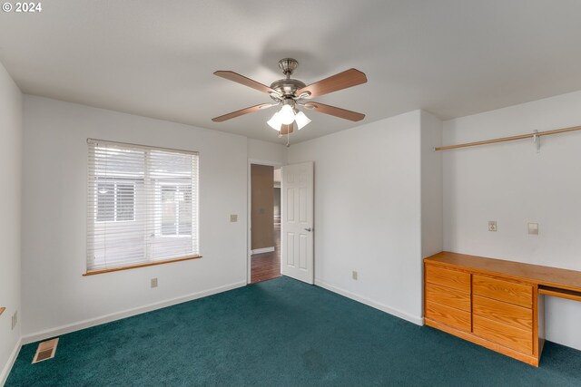 unfurnished bedroom with dark carpet and ceiling fan