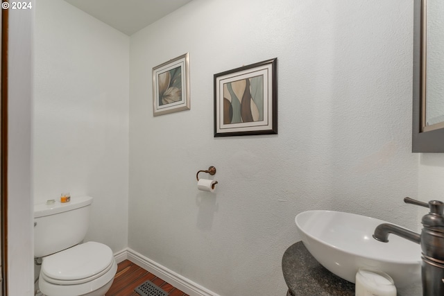 bathroom with sink, hardwood / wood-style flooring, and toilet