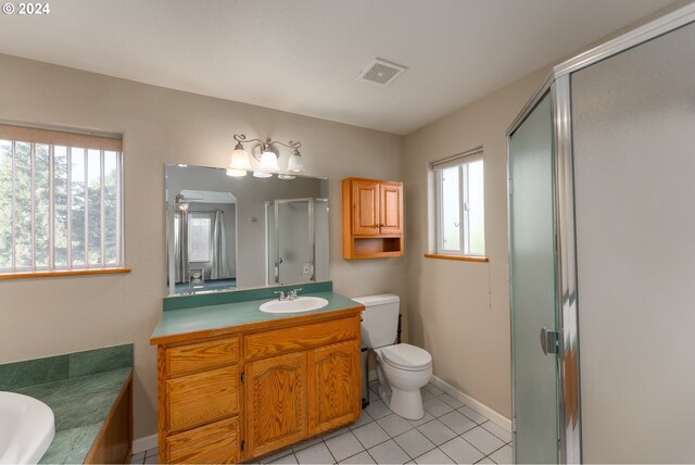 full bathroom featuring tile patterned floors, vanity, separate shower and tub, and a wealth of natural light