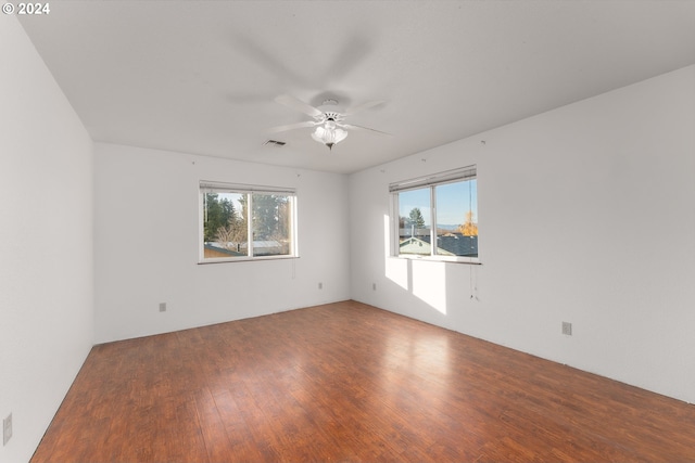 empty room with hardwood / wood-style floors and ceiling fan