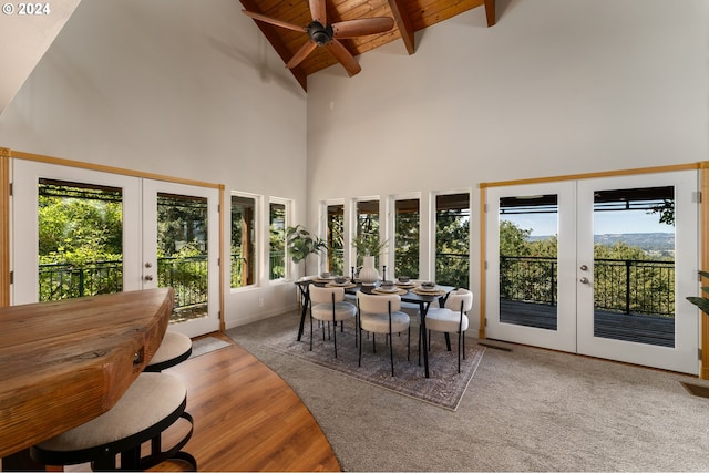 sunroom with lofted ceiling with beams, wooden ceiling, and french doors