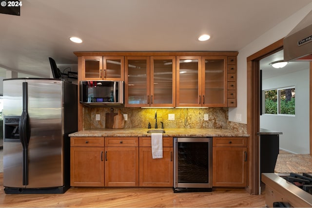 kitchen with tasteful backsplash, light stone countertops, beverage cooler, and stainless steel refrigerator with ice dispenser