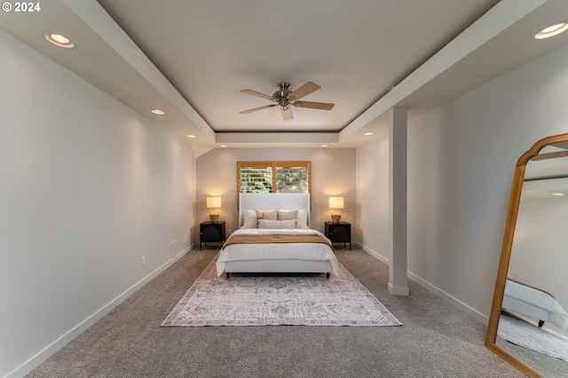 bedroom with ceiling fan, a raised ceiling, and carpet floors