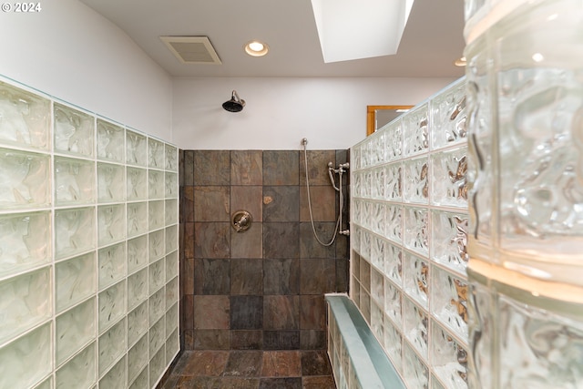 bathroom with walk in shower, a skylight, and tile walls