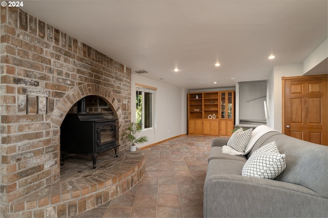 living room featuring tile patterned floors and a wood stove