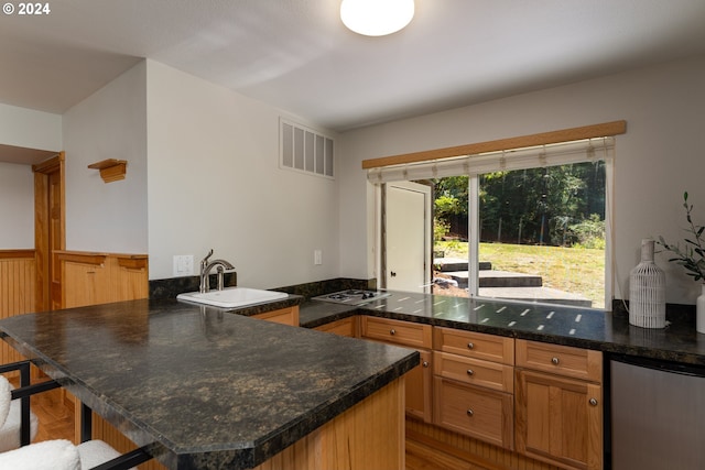 kitchen featuring refrigerator, sink, kitchen peninsula, gas stovetop, and light hardwood / wood-style flooring