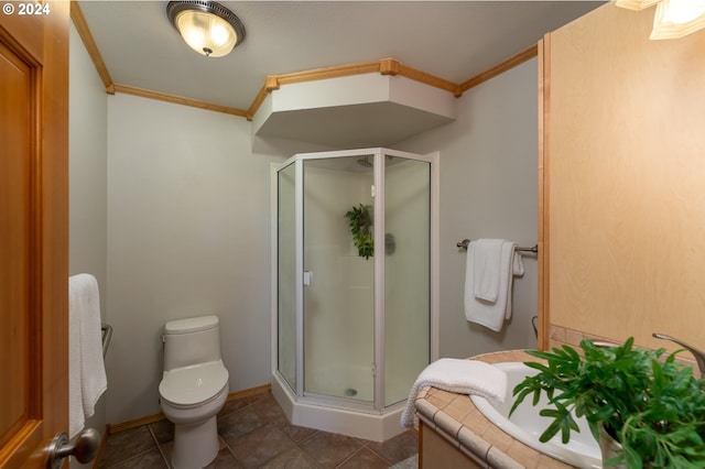 bathroom with tile patterned floors, toilet, a shower with shower door, ornamental molding, and vanity