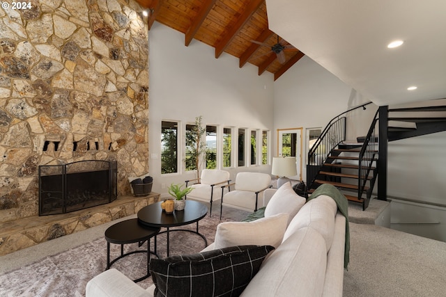 carpeted living room featuring high vaulted ceiling, beam ceiling, a fireplace, and wooden ceiling