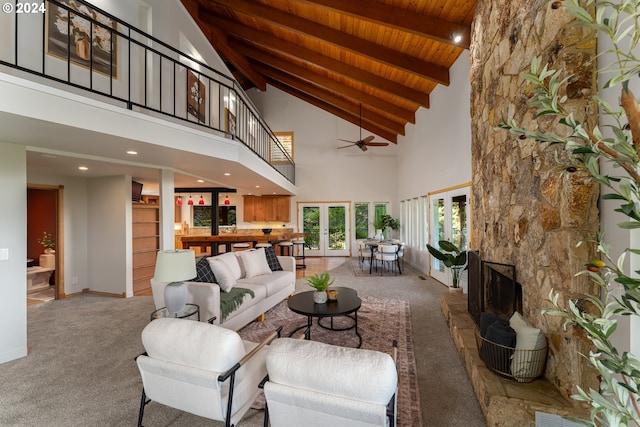 living room featuring a fireplace, carpet flooring, vaulted ceiling with beams, wood ceiling, and french doors