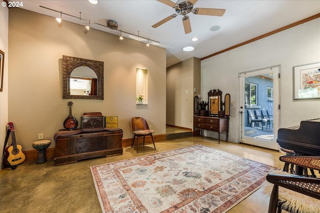 living area with concrete floors, crown molding, ceiling fan, and track lighting