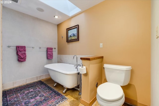 bathroom featuring tile patterned flooring, a skylight, a bathtub, and toilet