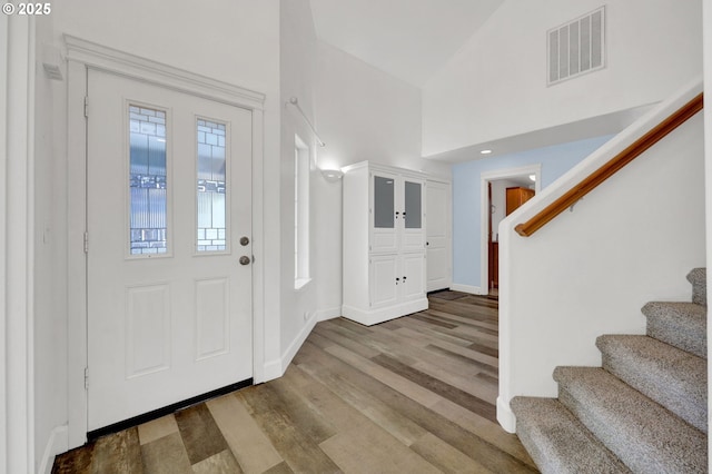 foyer entrance with a high ceiling and light hardwood / wood-style flooring