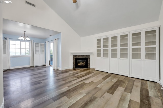 870 Kristen Way, Cottage Grove, OR 97424 - unfurnished living room featuring a chandelier, wood finished floors, a glass covered fireplace, and high vaulted ceiling