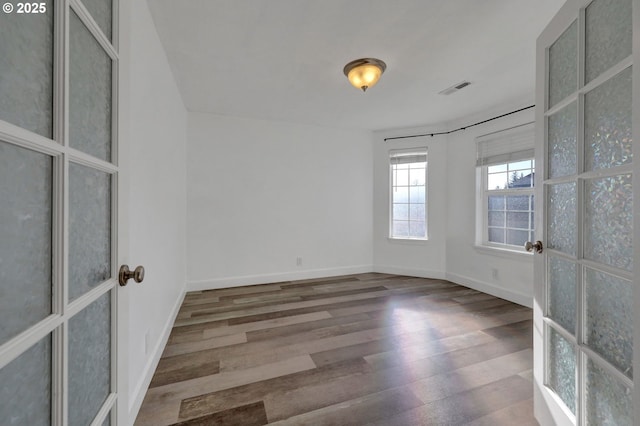 spare room with hardwood / wood-style floors and french doors