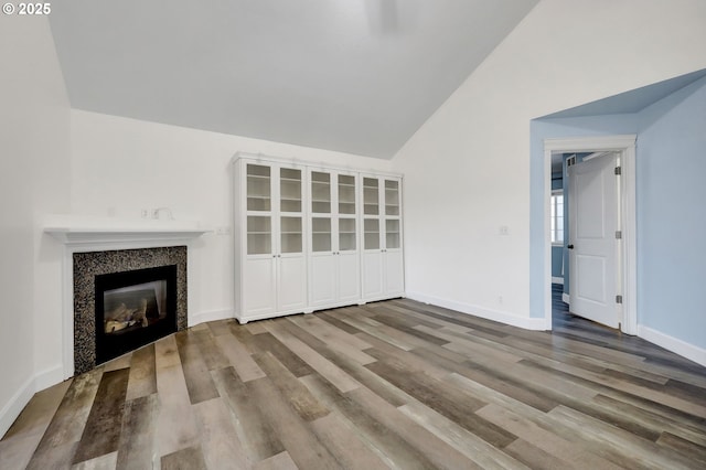 870 Kristen Way, Cottage Grove, OR 97424 - unfurnished living room featuring a glass covered fireplace, lofted ceiling, wood finished floors, and baseboards