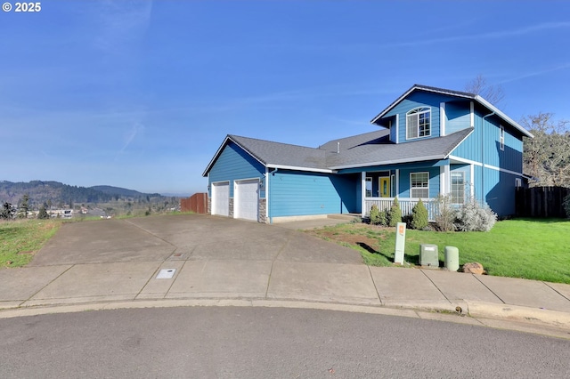 view of front of property featuring a porch, a garage, a mountain view, and a front lawn