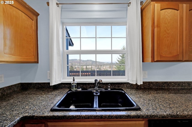 kitchen featuring sink, a mountain view, dishwasher, and dark stone countertops