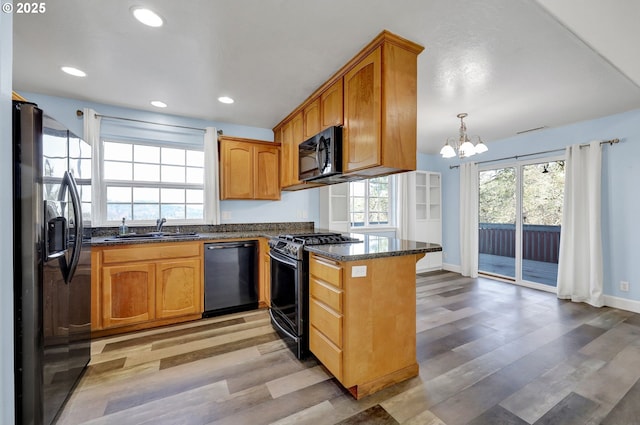 870 Kristen Way, Cottage Grove, OR 97424 - kitchen with a chandelier, light wood-type flooring, a peninsula, black appliances, and a sink