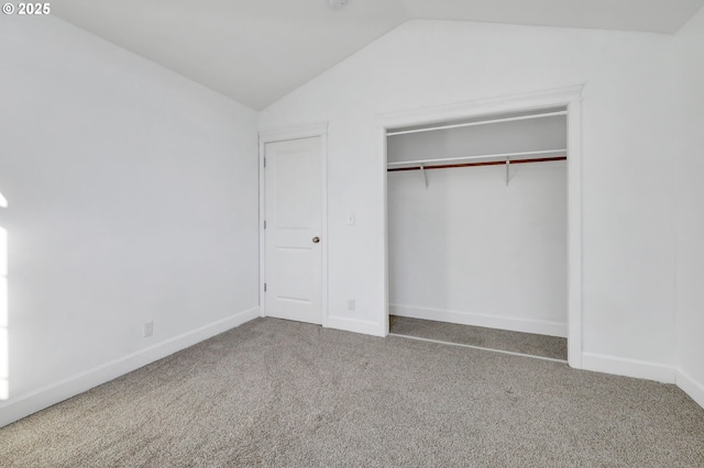 unfurnished bedroom with carpet floors, a closet, and vaulted ceiling