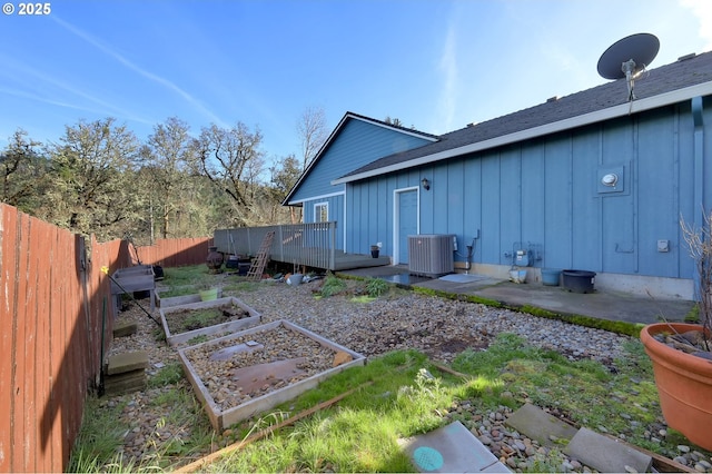 870 Kristen Way, Cottage Grove, OR 97424 - exterior space featuring board and batten siding, fence, central air condition unit, a wooden deck, and a vegetable garden