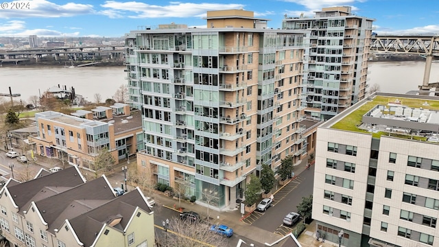 view of building exterior featuring central AC unit and a water view