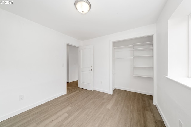 unfurnished bedroom featuring light wood-type flooring and a closet