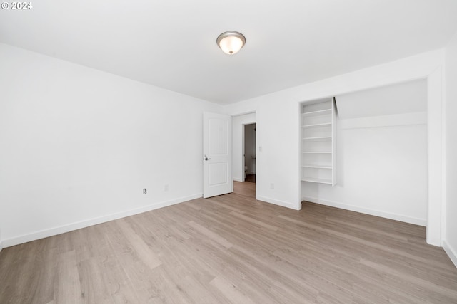 unfurnished bedroom with a closet and light hardwood / wood-style flooring