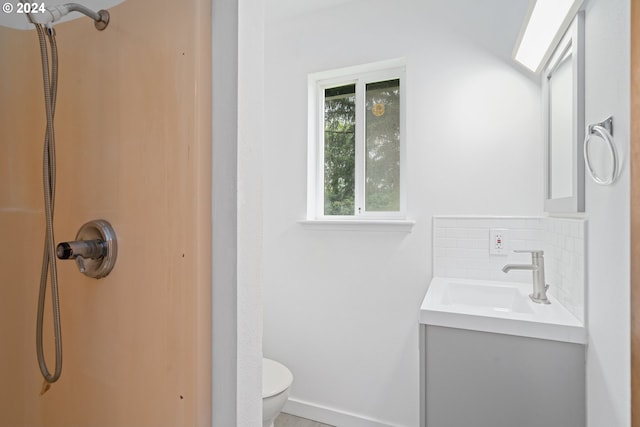 bathroom with vanity, tasteful backsplash, and toilet