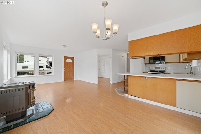 kitchen with sink, an inviting chandelier, white refrigerator, pendant lighting, and stainless steel electric range