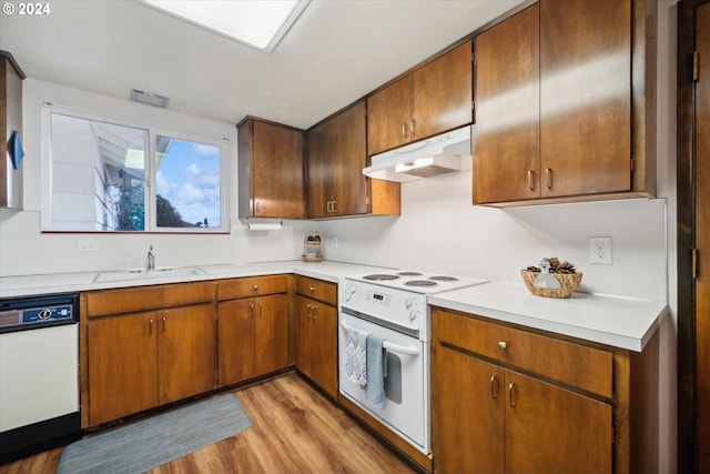 kitchen featuring white appliances, light hardwood / wood-style flooring, and sink