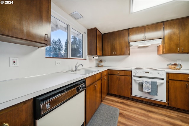 kitchen featuring light wood-type flooring, white appliances, and sink