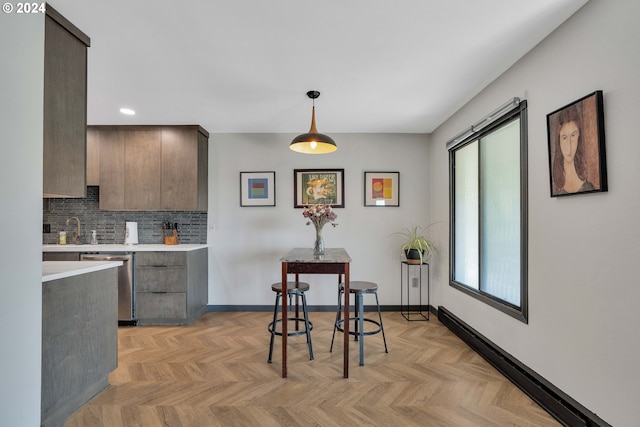 kitchen featuring dishwasher, light parquet floors, hanging light fixtures, and dark brown cabinetry