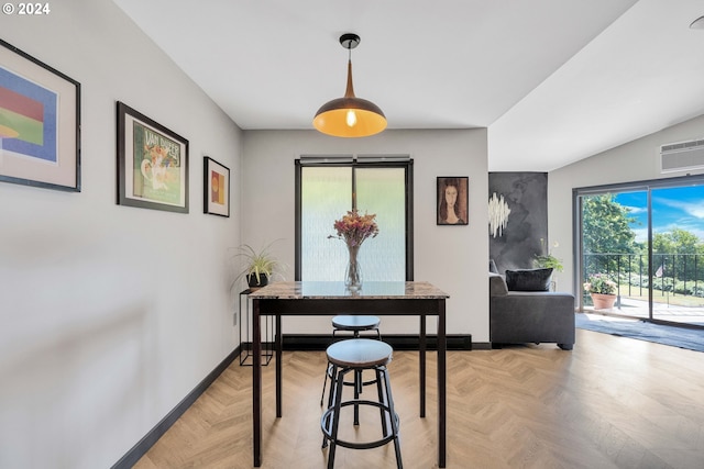 dining area featuring lofted ceiling, a wall unit AC, and light parquet floors