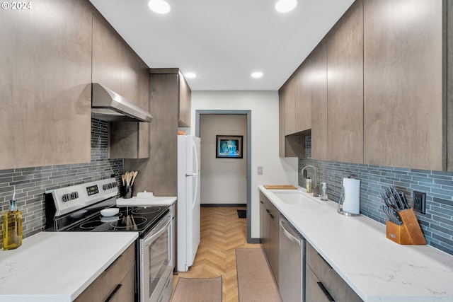 kitchen featuring tasteful backsplash, sink, stainless steel appliances, exhaust hood, and light parquet floors