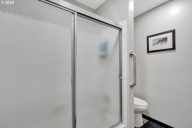 bathroom featuring toilet and an enclosed shower