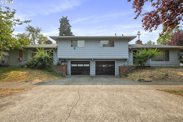 split level home with cooling unit and a garage