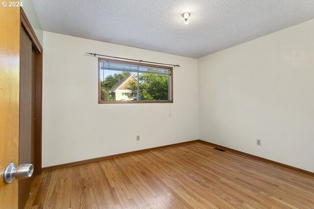 spare room with hardwood / wood-style flooring and a textured ceiling