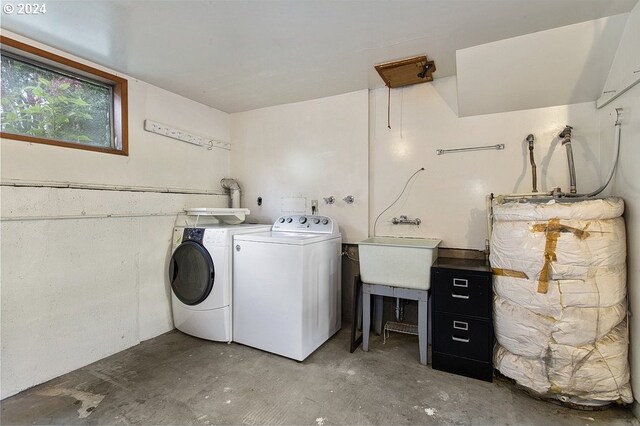 laundry room with sink, water heater, and washing machine and clothes dryer