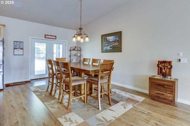 191 SW 67th St, Redmond, OR 97756 - dining space with french doors, vaulted ceiling, baseboards, a chandelier, and light wood-style floors