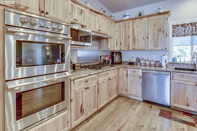 191 SW 67th St, Redmond, OR 97756 - kitchen with light brown cabinetry, light stone countertops, a sink, light wood-style flooring, and appliances with stainless steel finishes