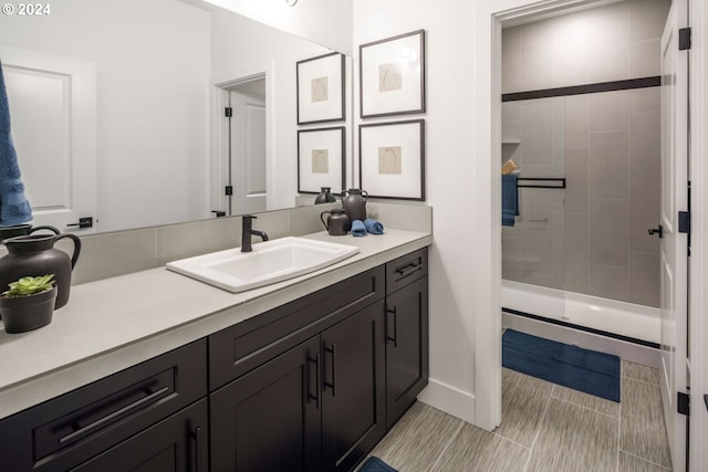 bathroom featuring tile patterned flooring, vanity, and tiled shower