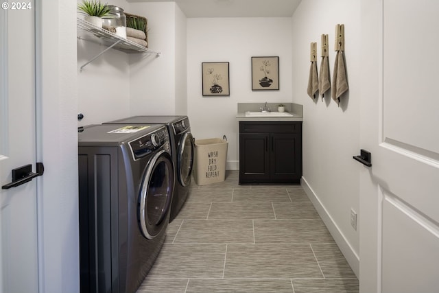 washroom featuring cabinets, sink, and washer and dryer