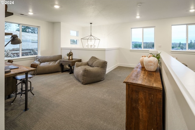 carpeted living room with plenty of natural light and a chandelier