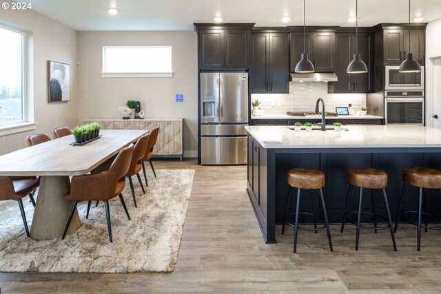 kitchen with a healthy amount of sunlight, sink, light hardwood / wood-style flooring, and stainless steel appliances