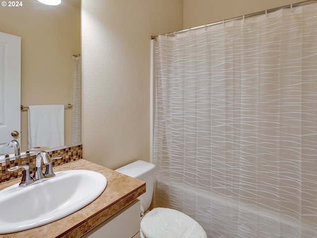 bathroom featuring decorative backsplash, curtained shower, vanity, and toilet